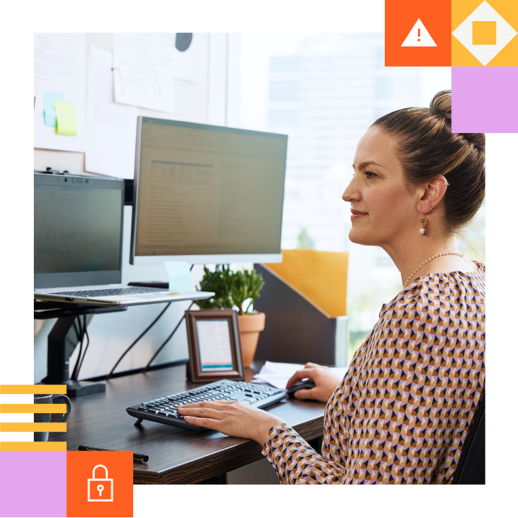 Woman looking at cyber claims on two screens